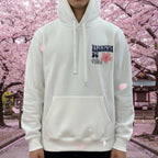 White hoodie with text and graphics on a mannequin in a store setting.